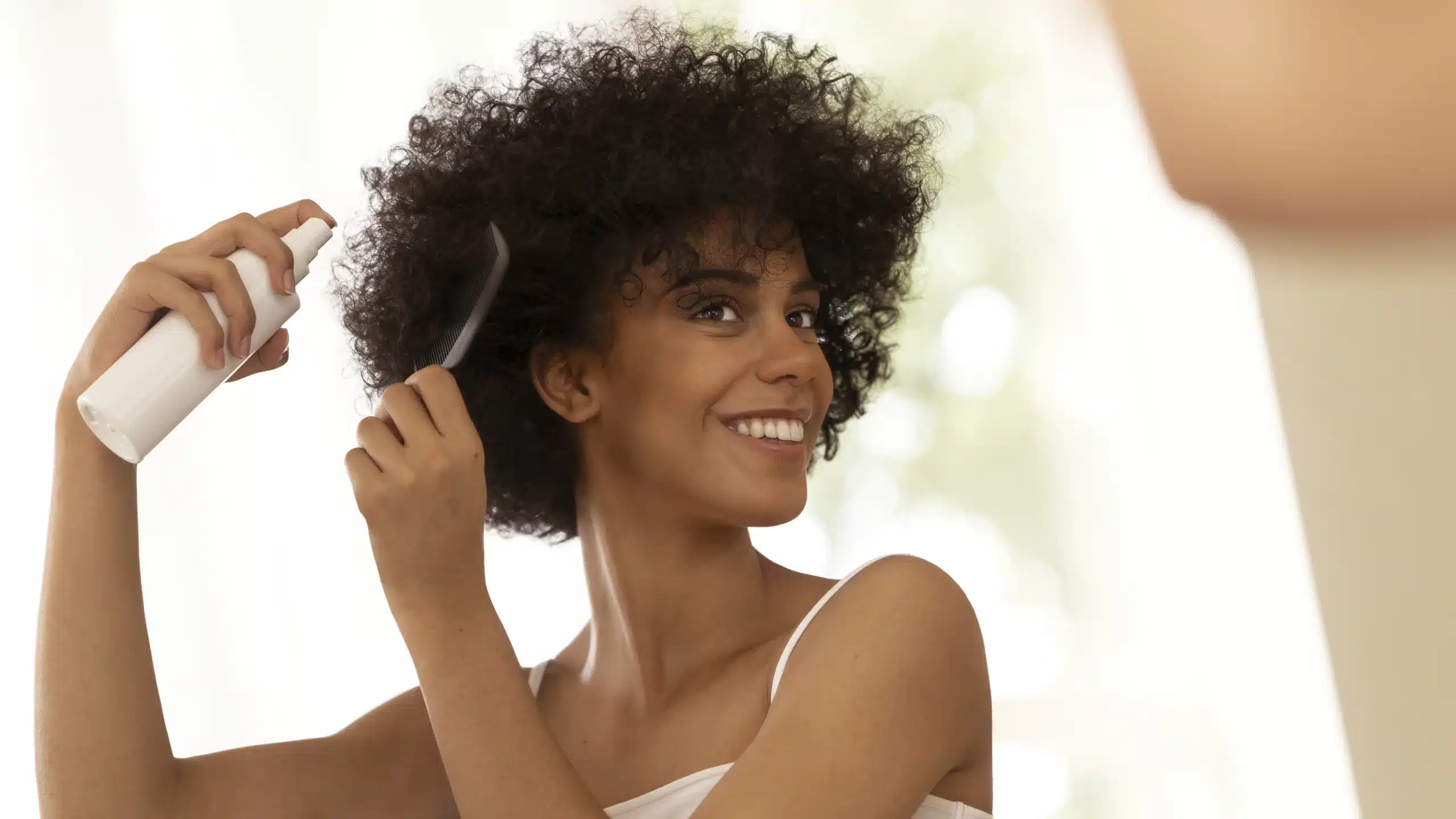 Femme hydratant ses cheveux avec un peigne