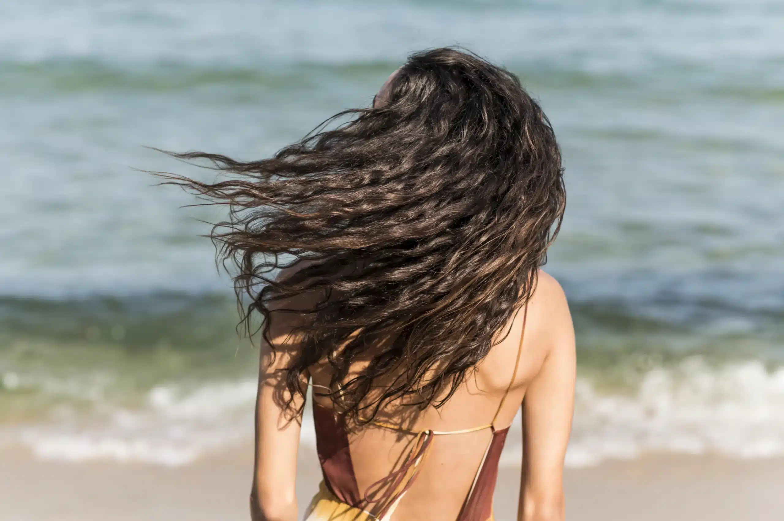 Femme secouant ses cheveux à la plage